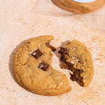 A chocolate chunk vegan gluten free cookie broken in half