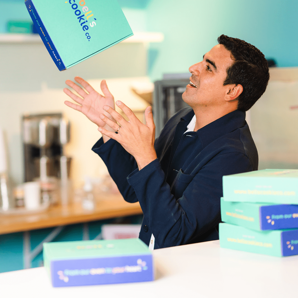 Tomas throwing a 12 cookie box in the air